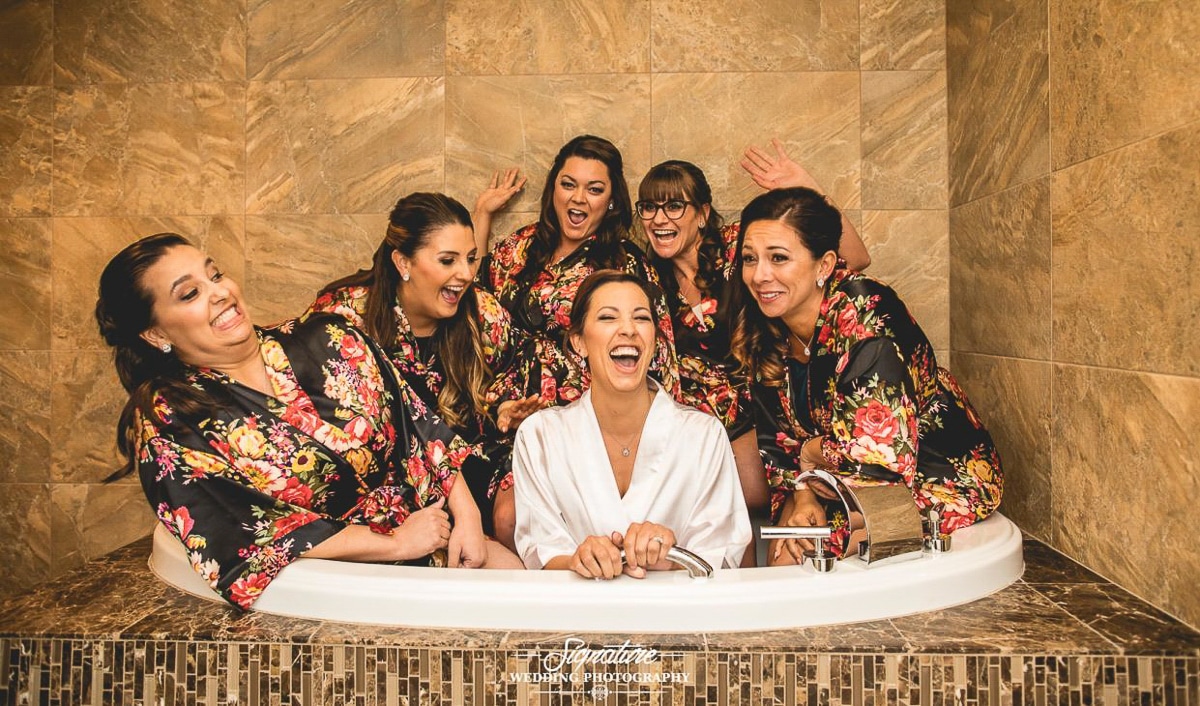 Bride and bridesmaids in robes in tub fun picture