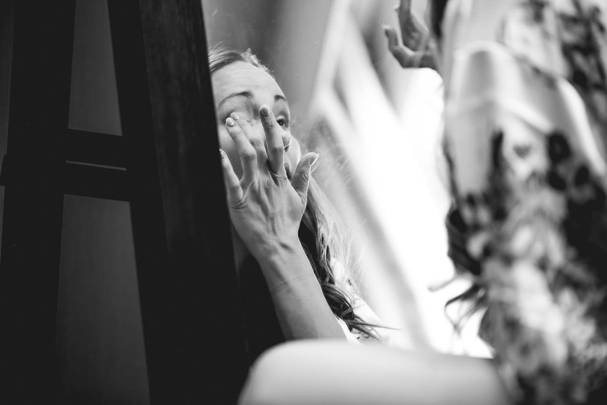 Bridesmaid doing her makeup black and white