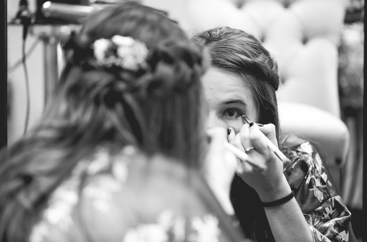 Bridesmaid doing her makeup black and white