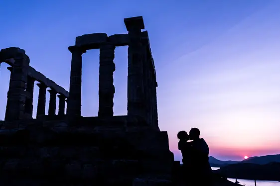 Bride and groom kissing at sunset silhouette