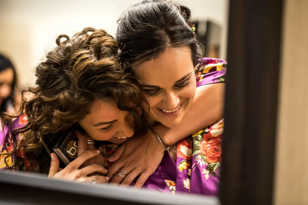 Bridesmaids hugging while getting ready