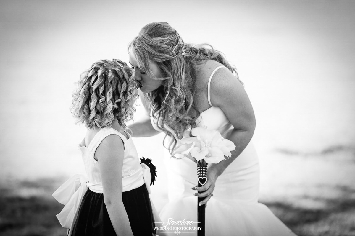 Bride kissing flower girl black and white