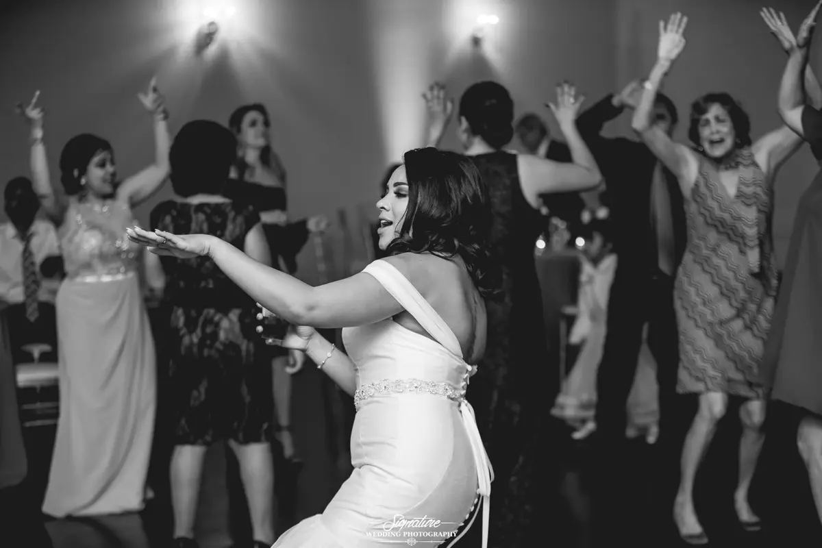 Bride dancing with wedding guests black and white