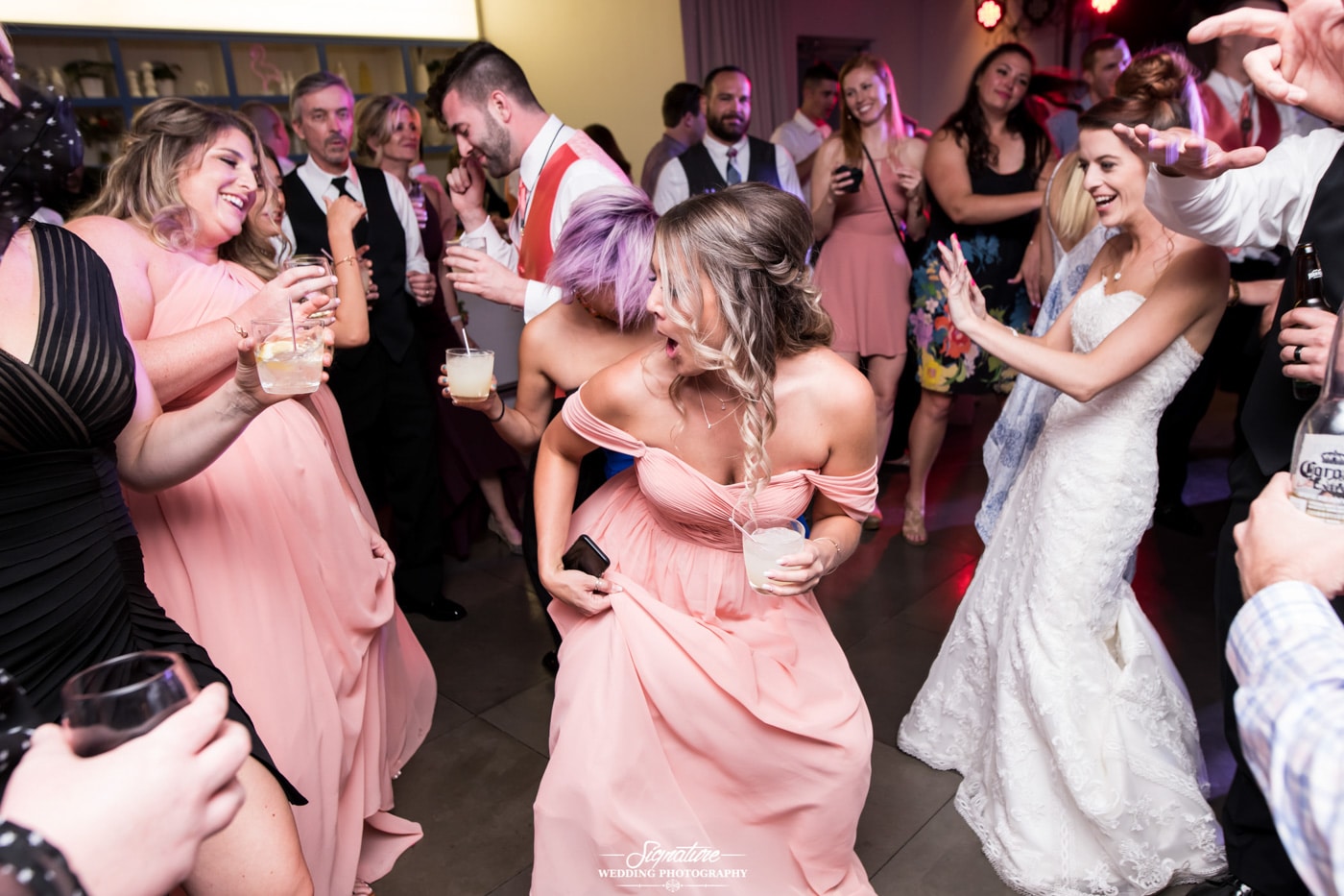 Bride and groom dancing with wedding guests candid