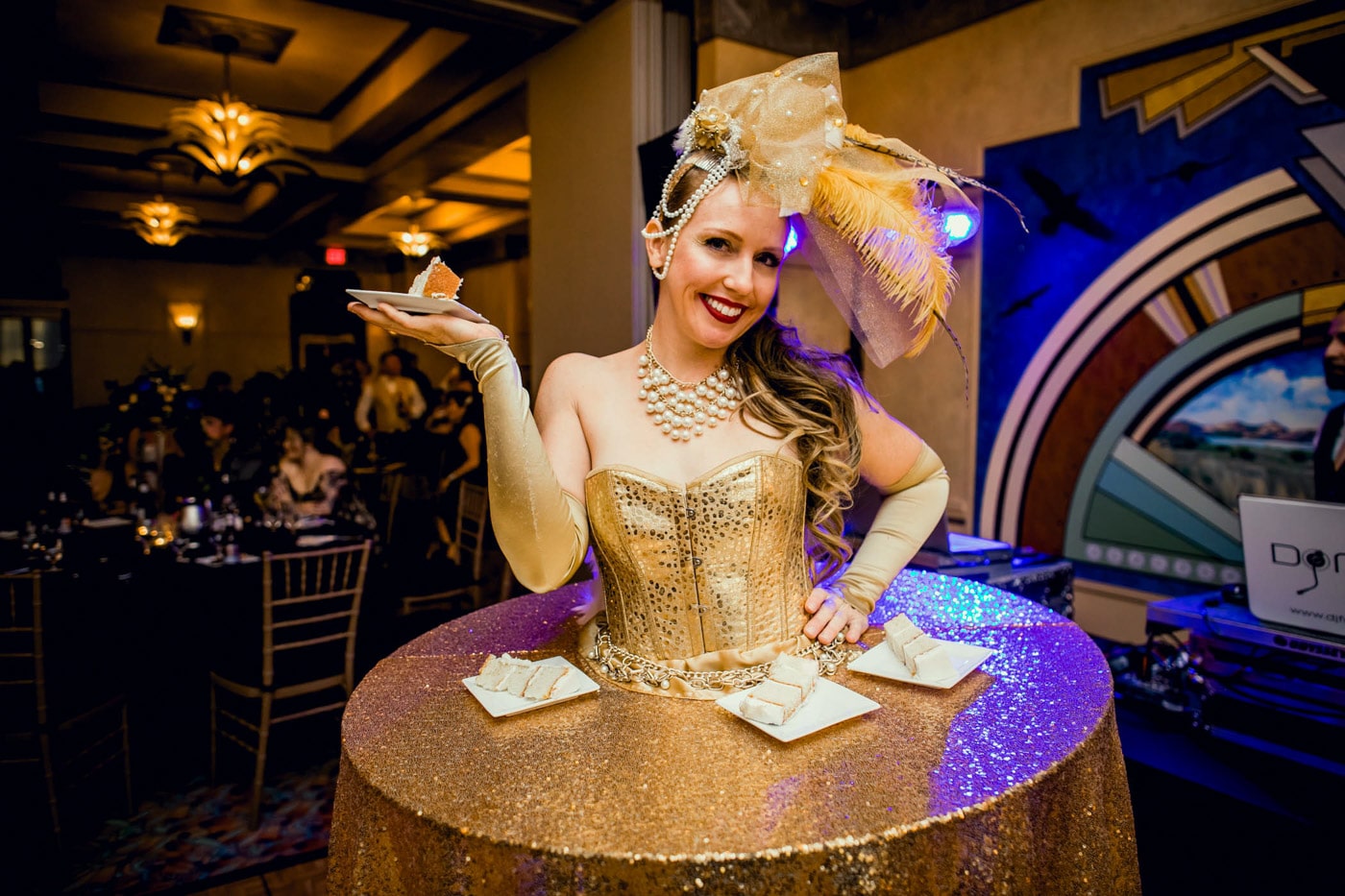 Woman with gold table dress offering cake