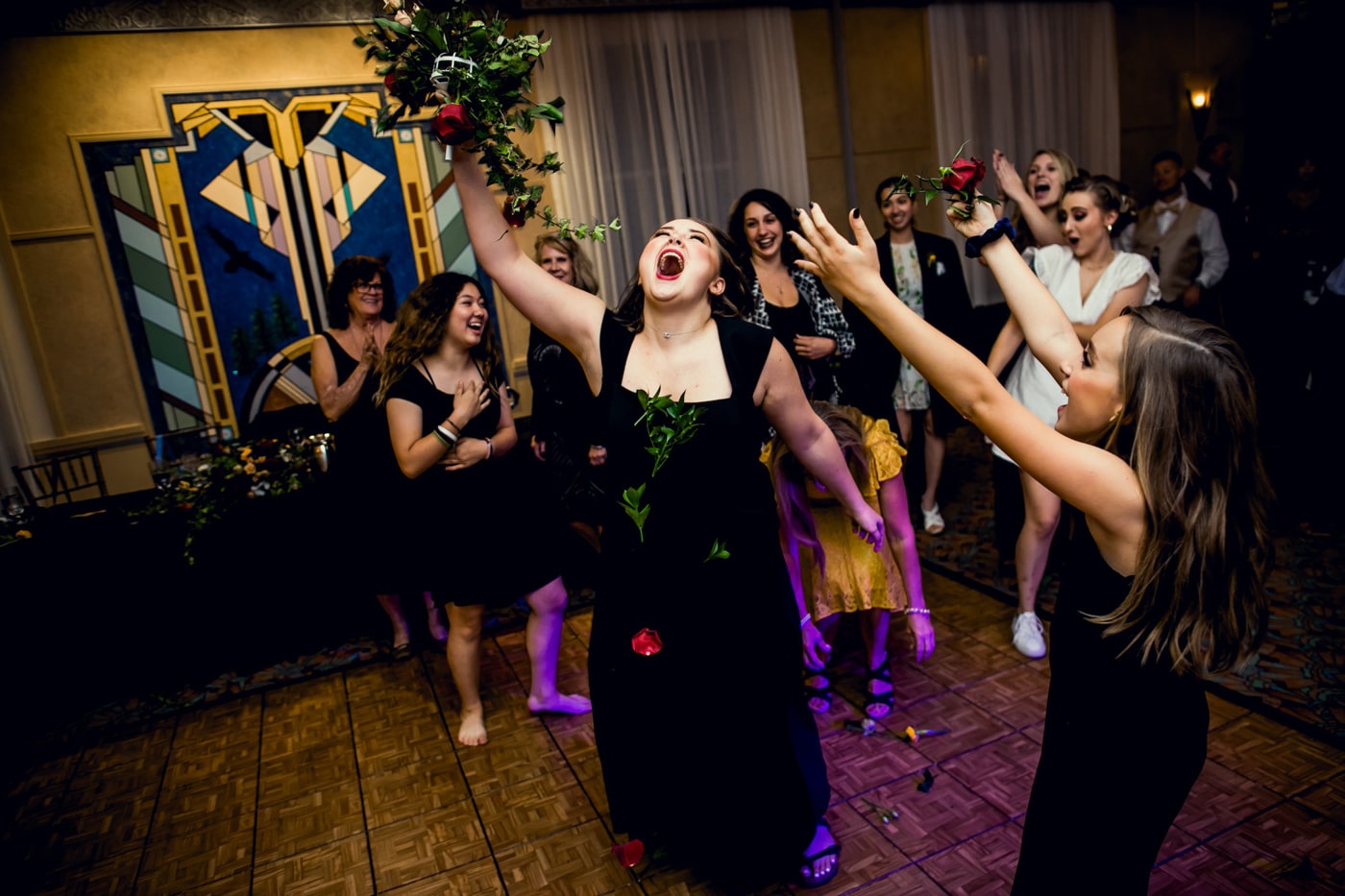 Wedding guest catching bouquet during reception