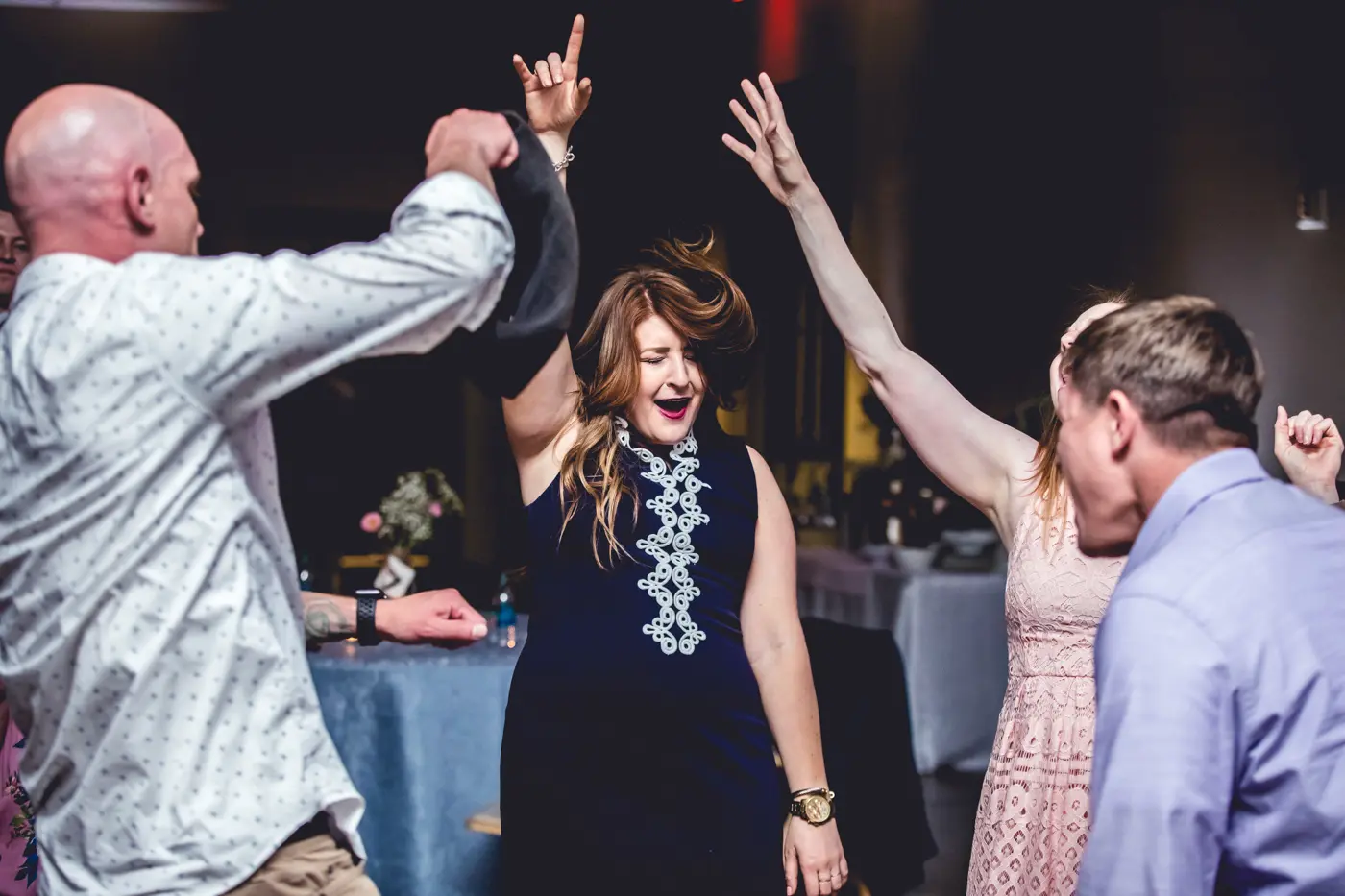 Wedding guests dancing with arms up candid