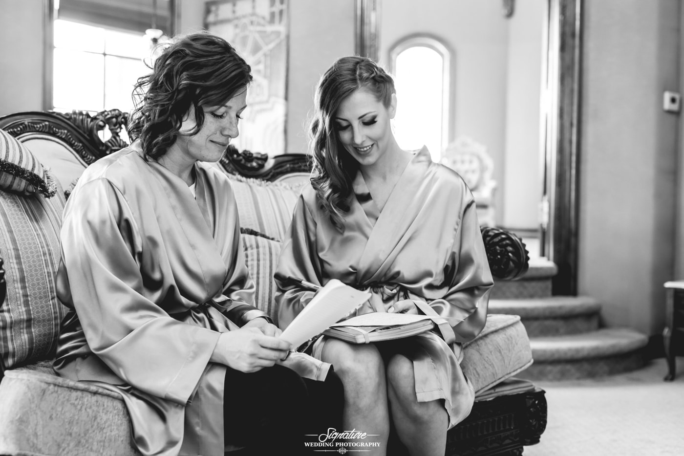 Bridesmaids reading letter in robes black and white