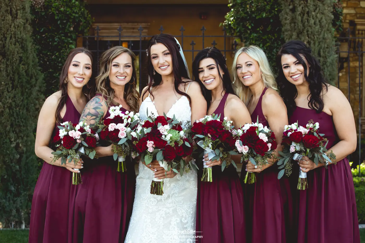 Bride and bridesmaids smiling at camera