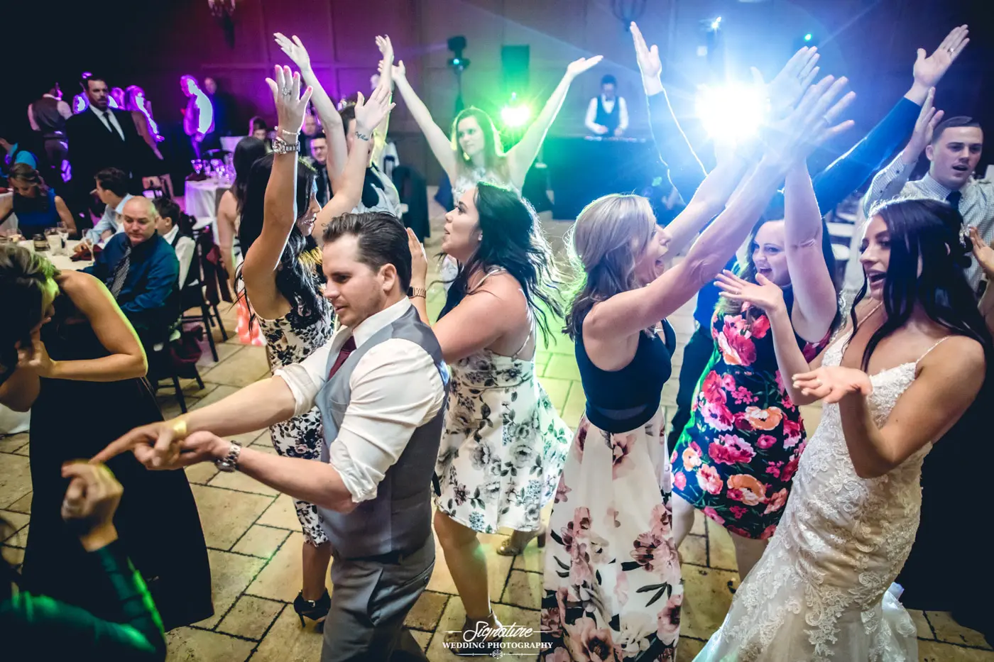 Bride and groom dancing with wedding guests candid