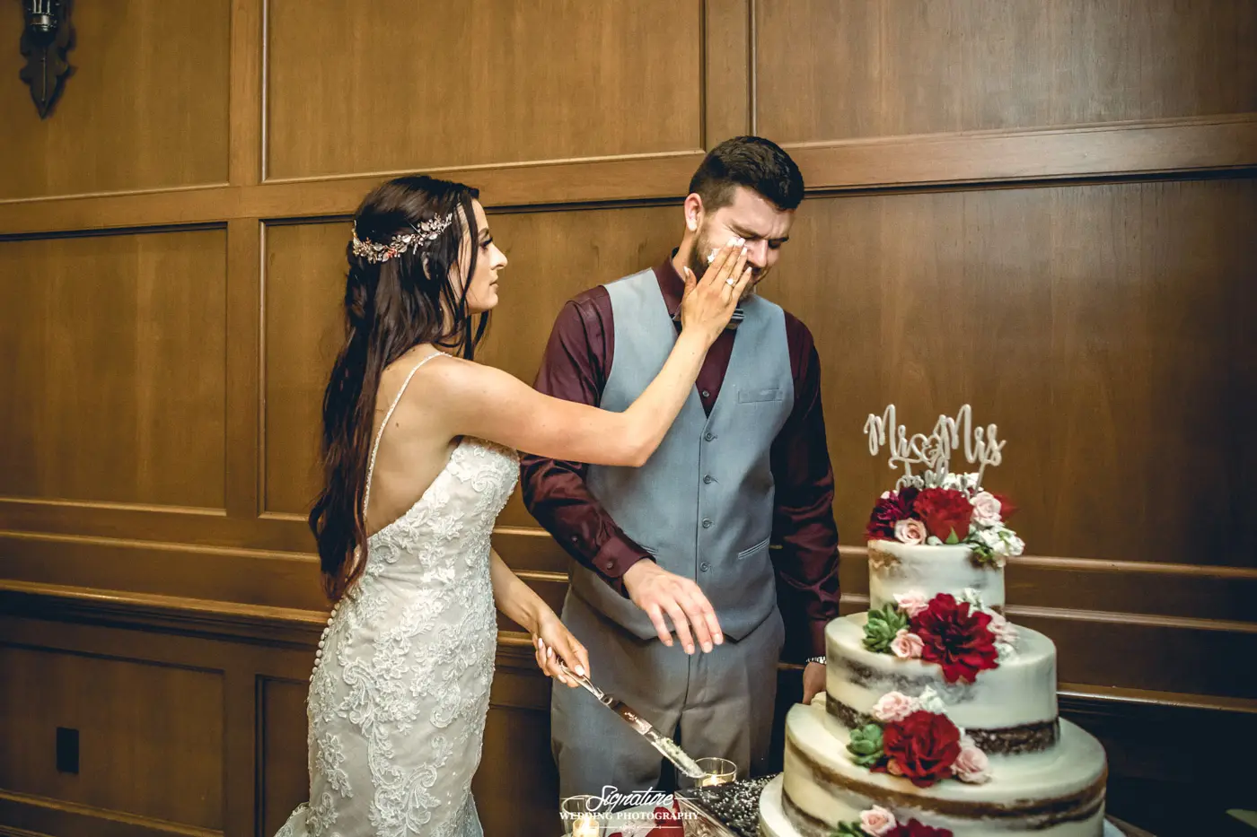 Bride putting cake on groom's face