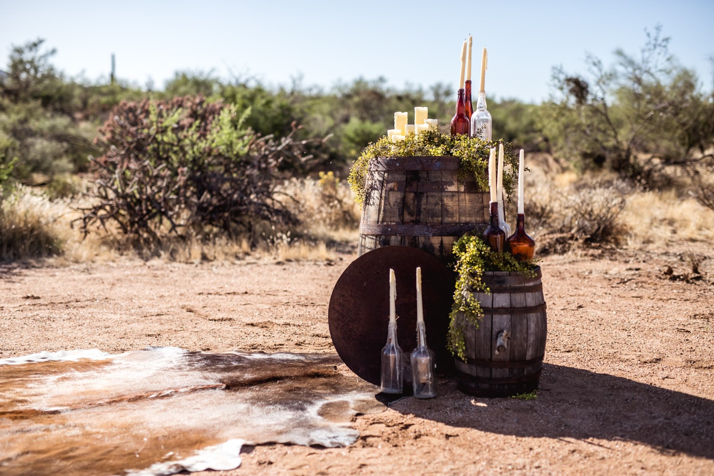 Barrels in desert with candles in glasses
