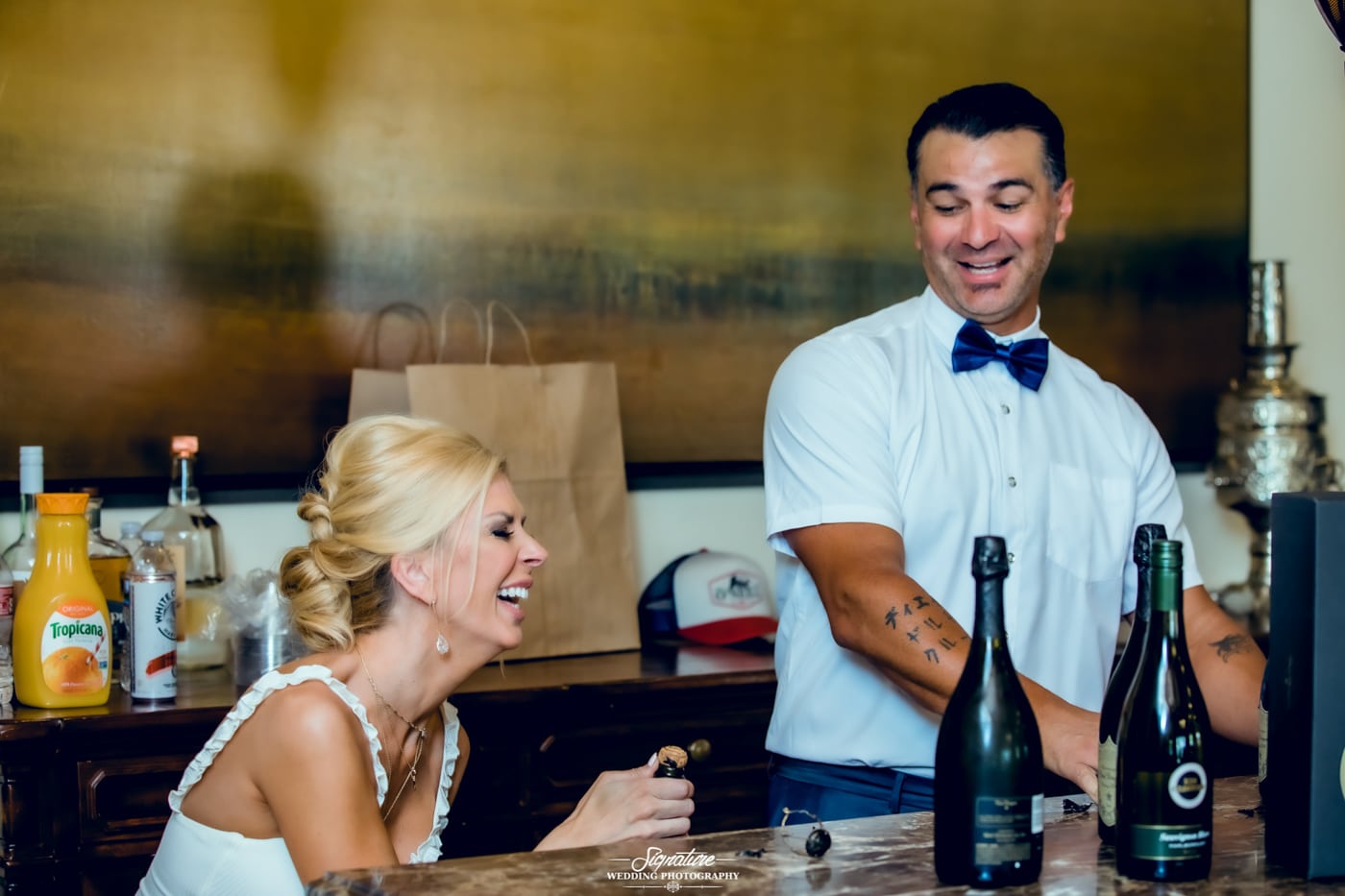 Bride and groom behind bar laughing