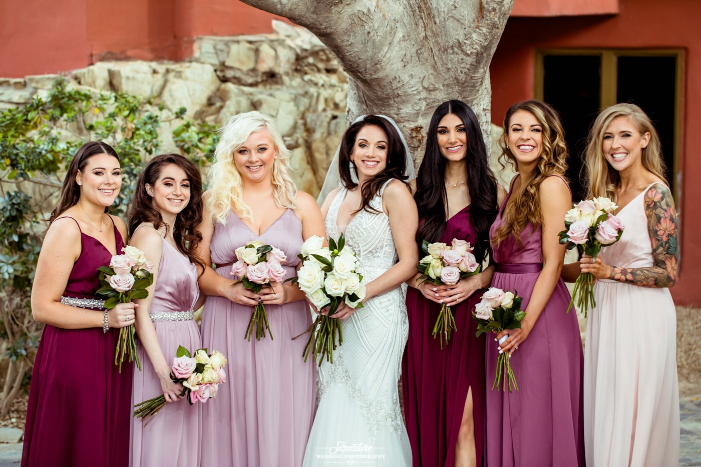 Bride and bridesmaids smiling at camera