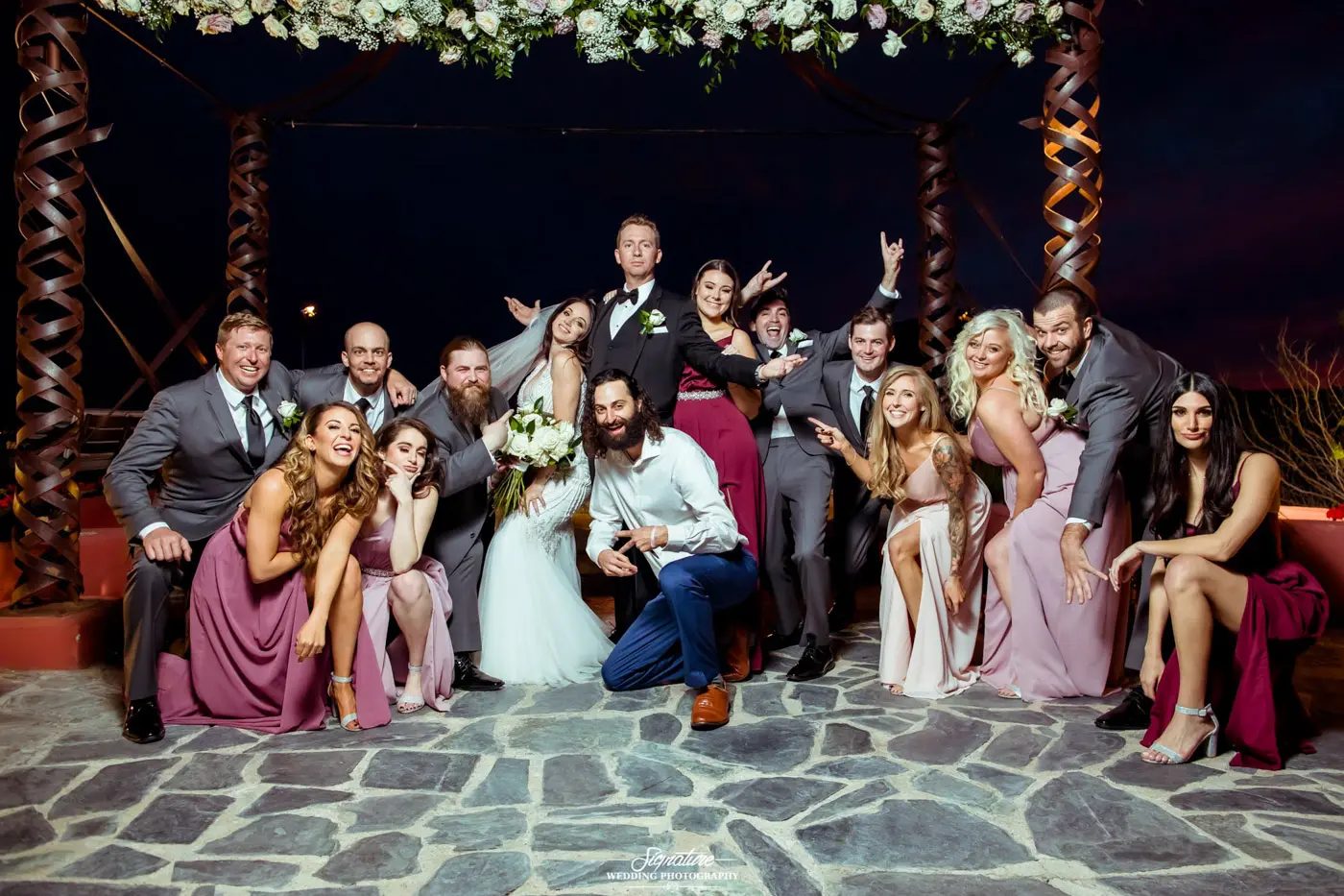 Bride and groom with wedding party in fun pose