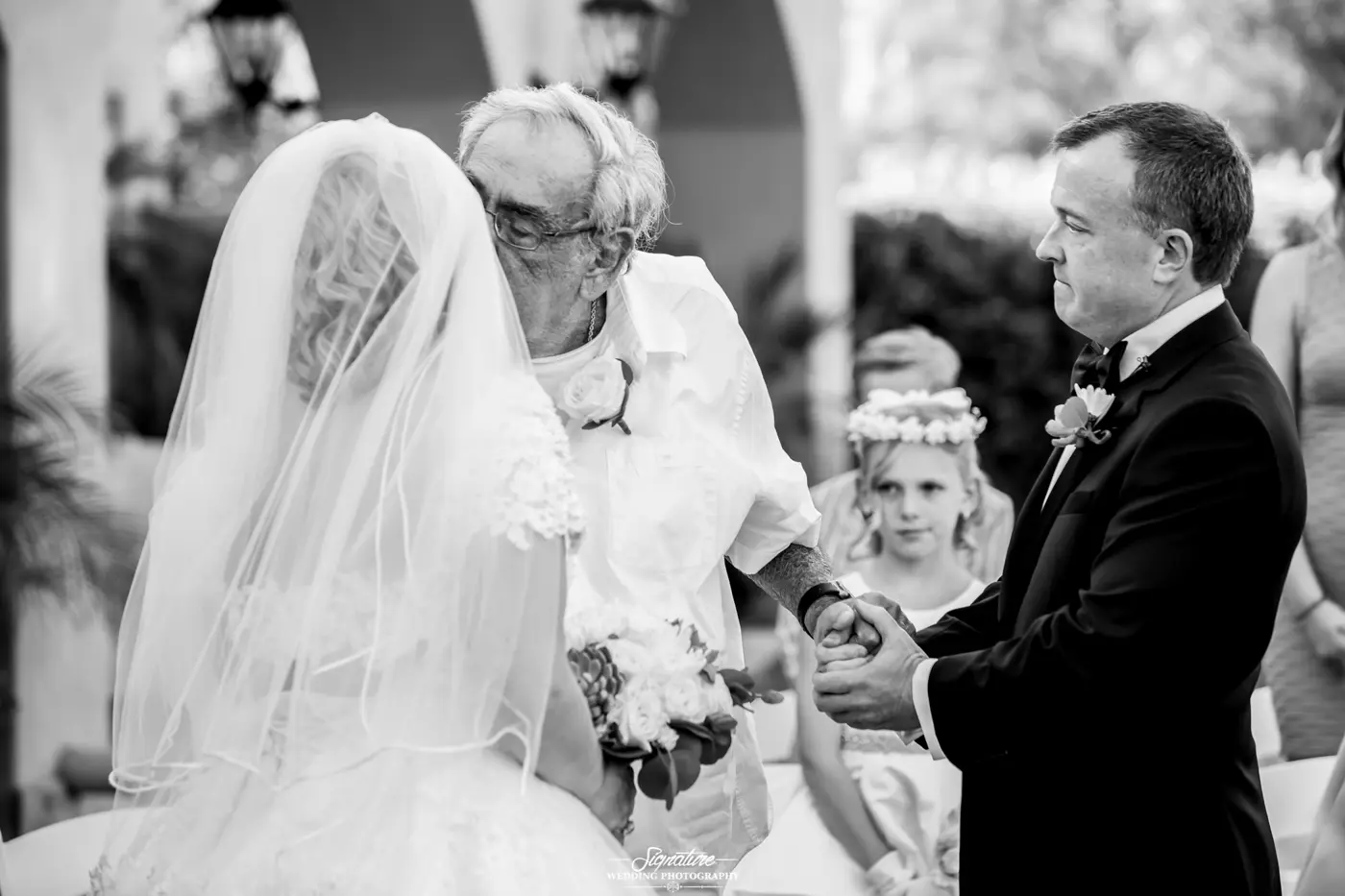 Patriarch kissing bride with groom black and white