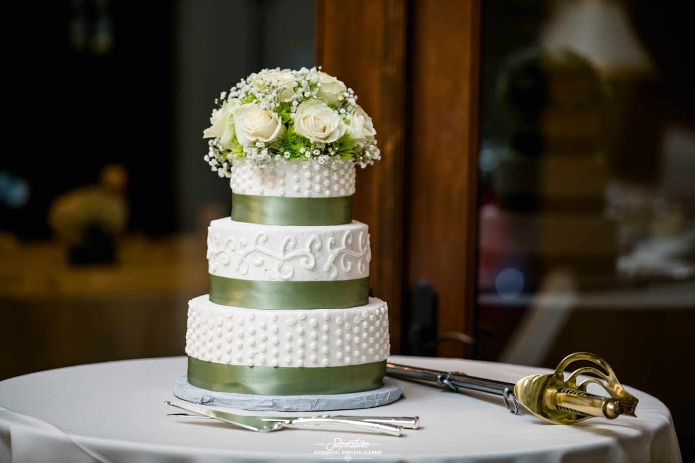 Wedding cake with green ribbon and flowers