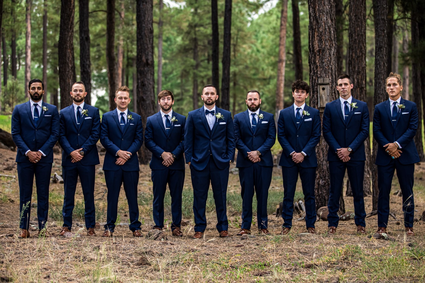 Groom and groomsmen in a line in forest