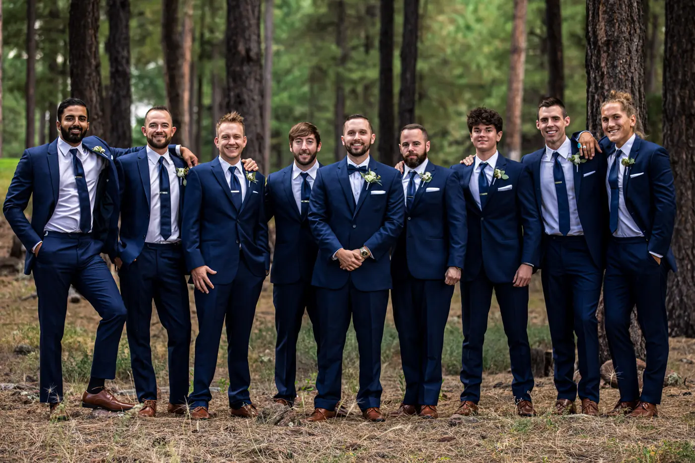 Groom and groomsmen smiling at camera