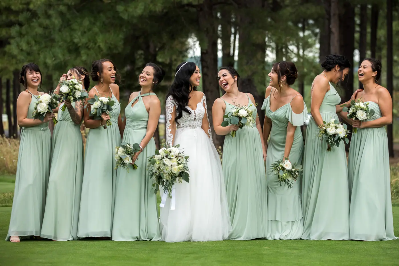 Bride and bridesmaids laughing together outside