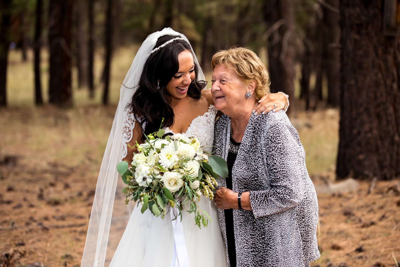 Bride smiling with arm around matriarch outside