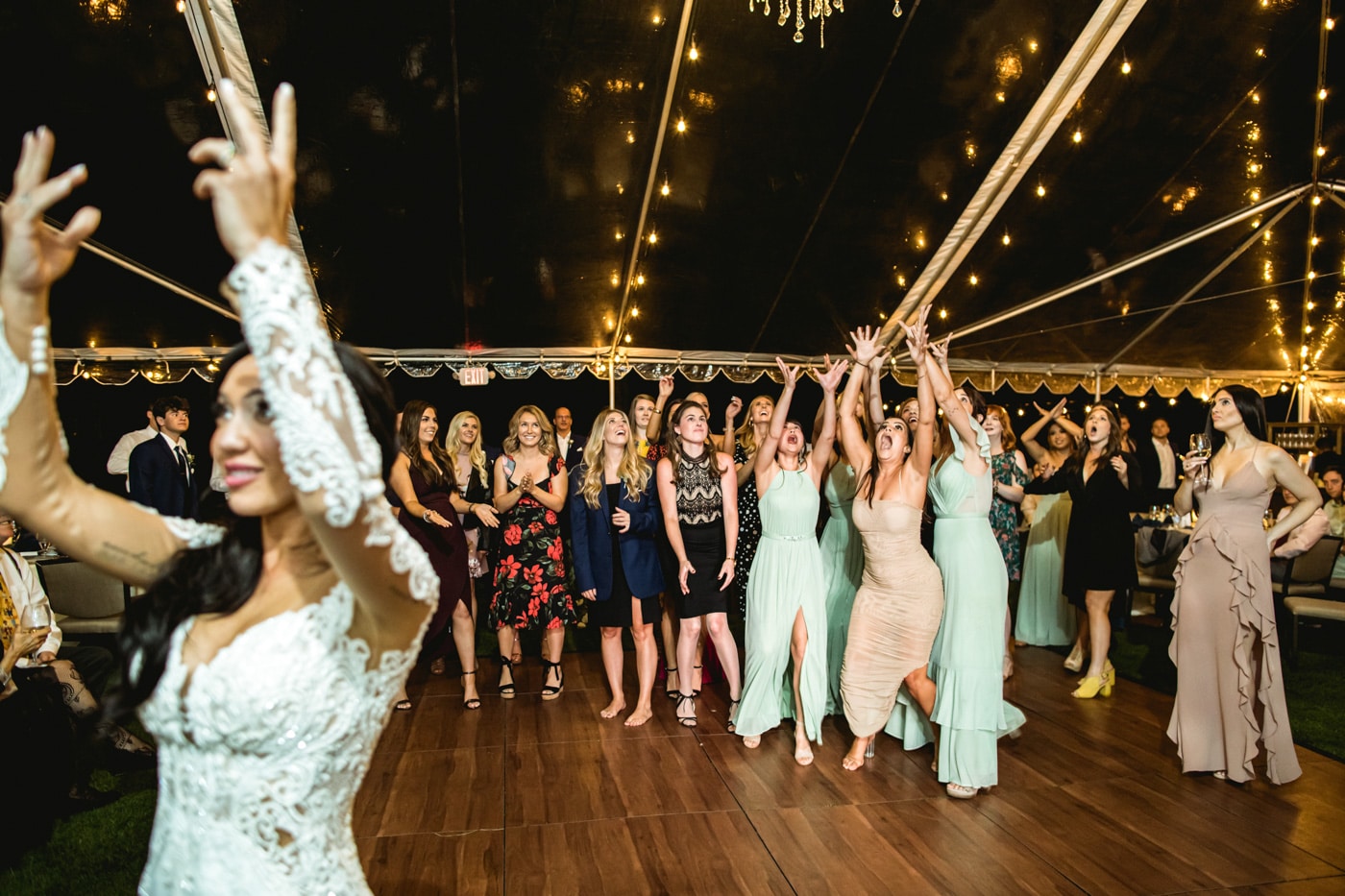 Ladies trying to catch bouquet toss at reception