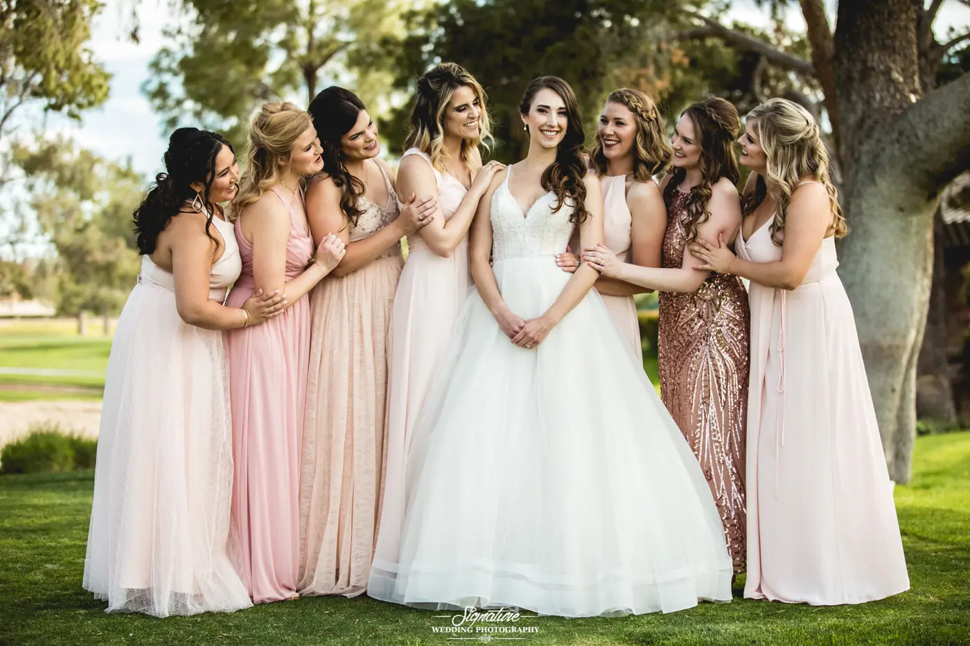 Bridesmaids smiling all looking at bride