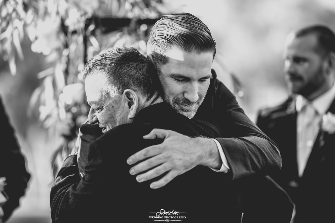 Patriarch and groom hugging black and white