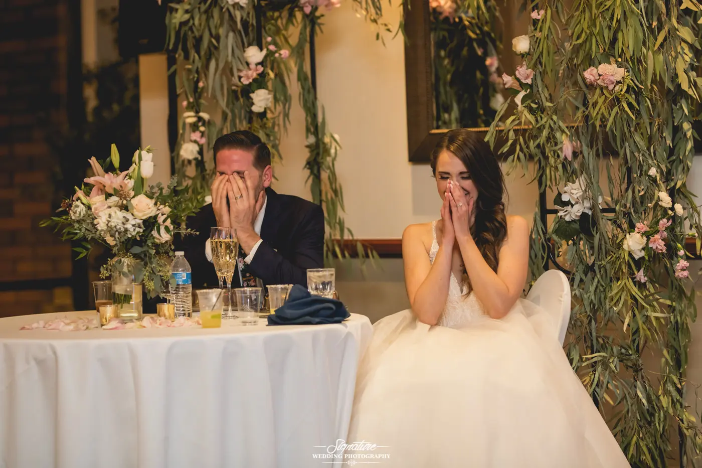 Bride and groom laughing at sweetheart table