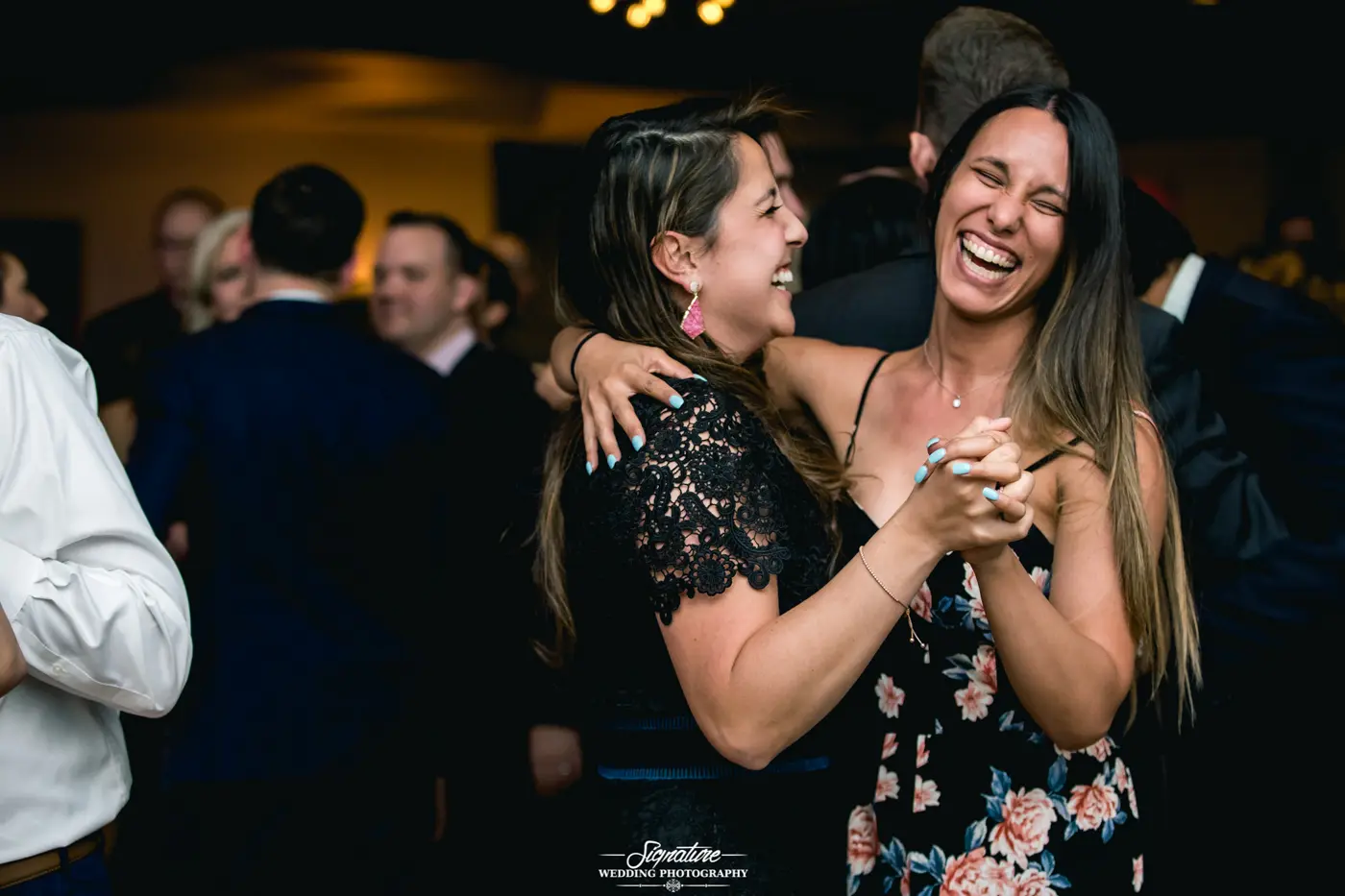 Wedding guests dancing together laughing