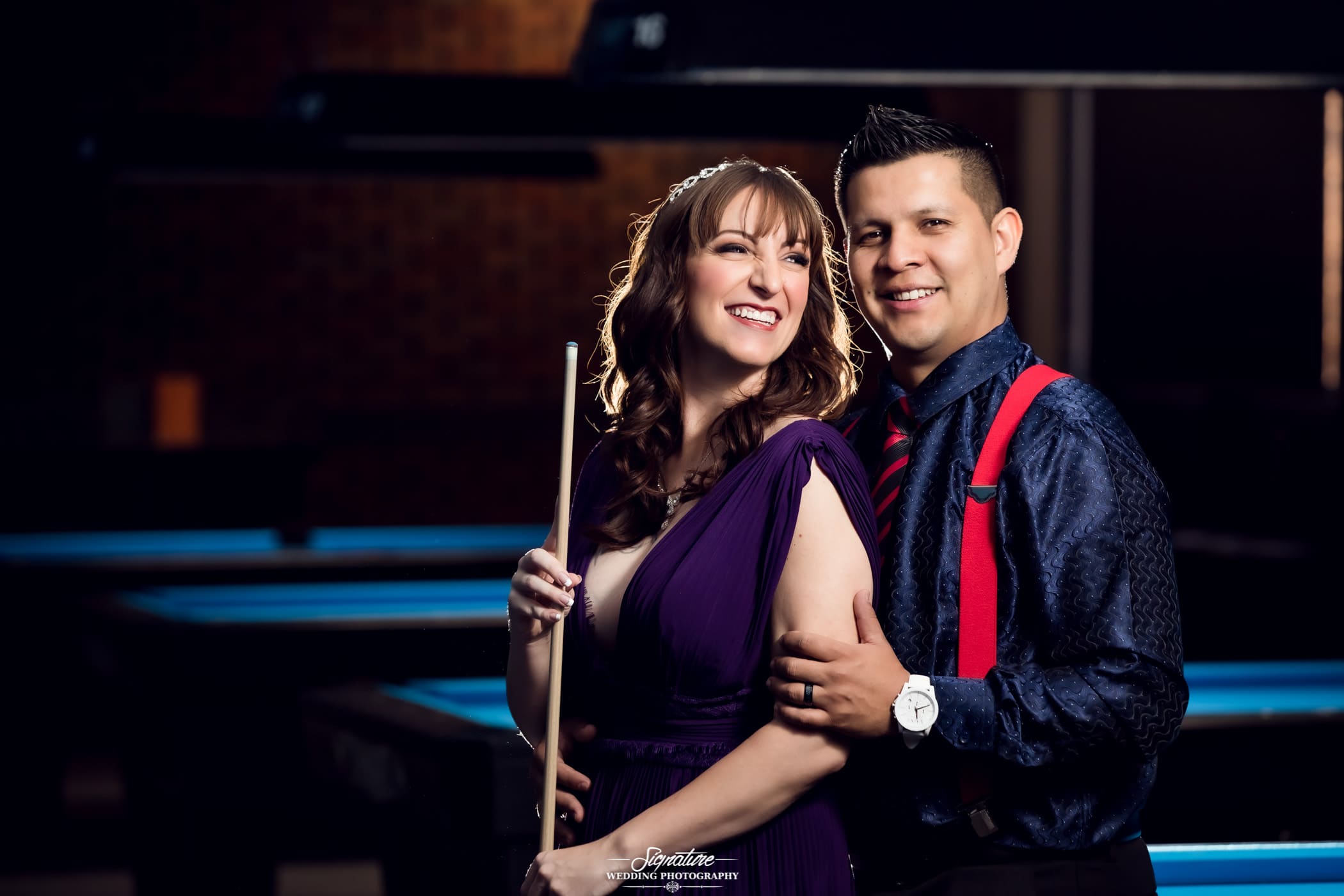Couple smiling with billiards cue stick