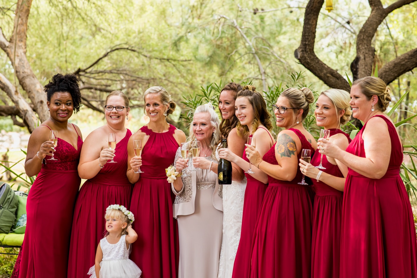 Bride and bridal party holding drinks smiling