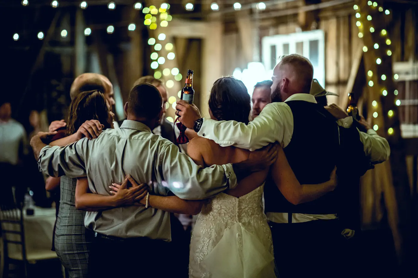 Bride and groom huddled with wedding guests