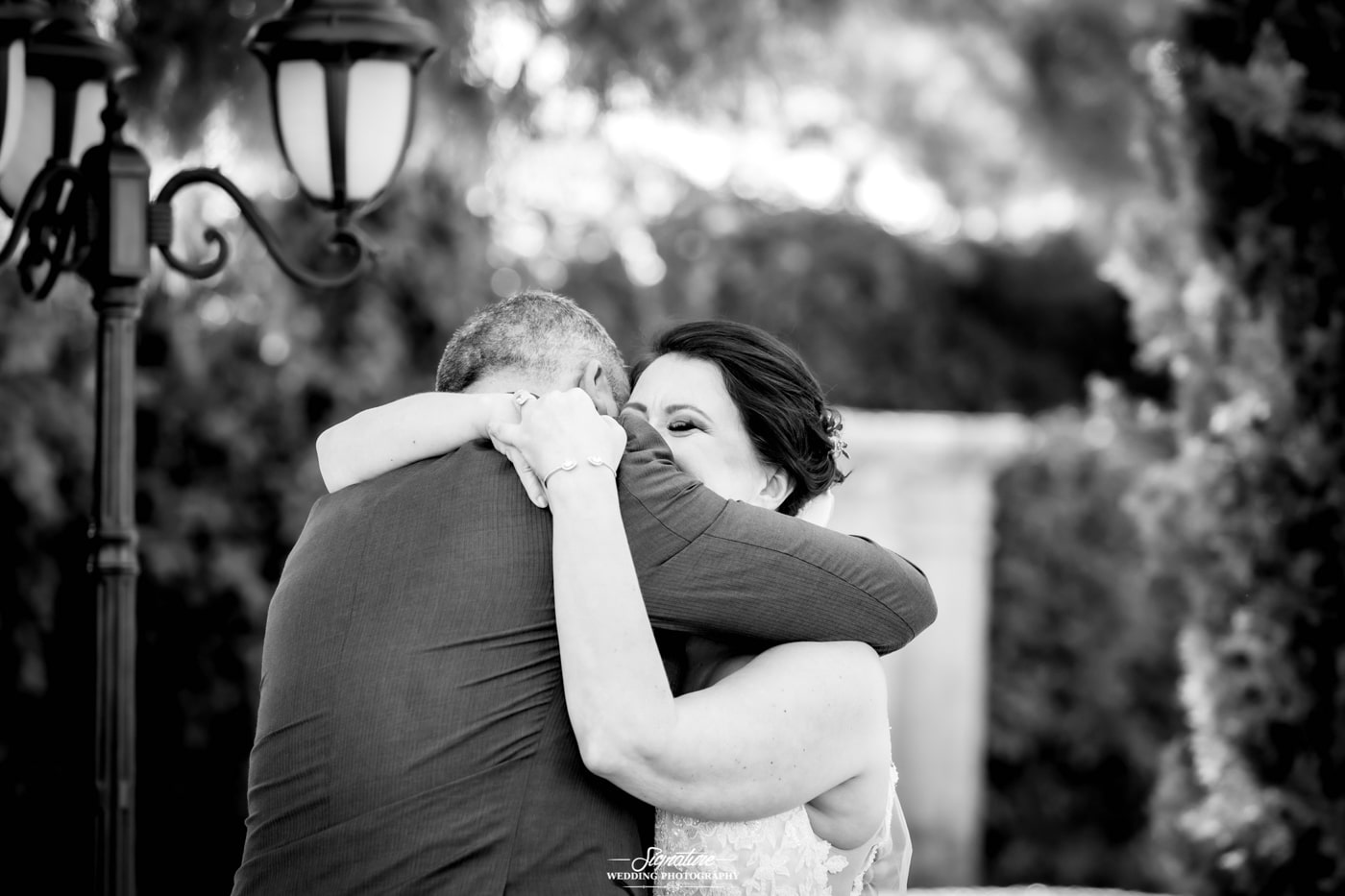 Bride and groom hugging outside black and white
