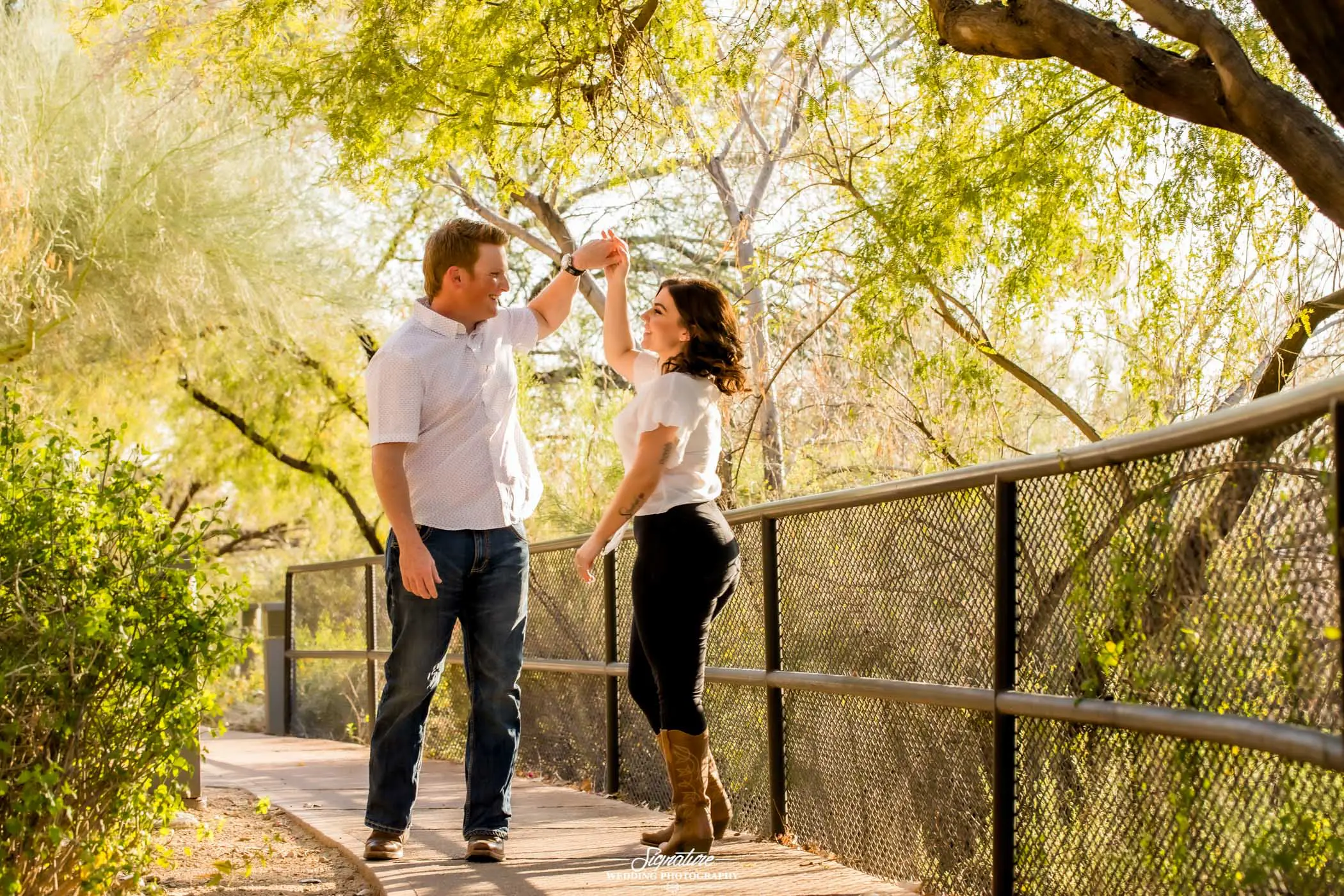 Man spinning woman under tree