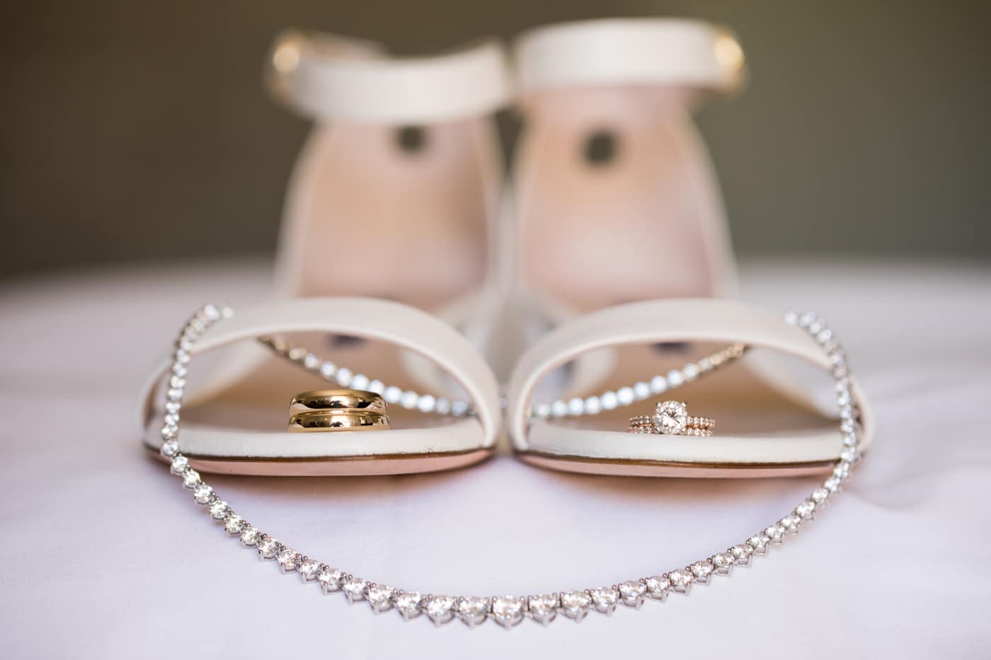 Detail shot of wedding rings, shoes, and jewelry