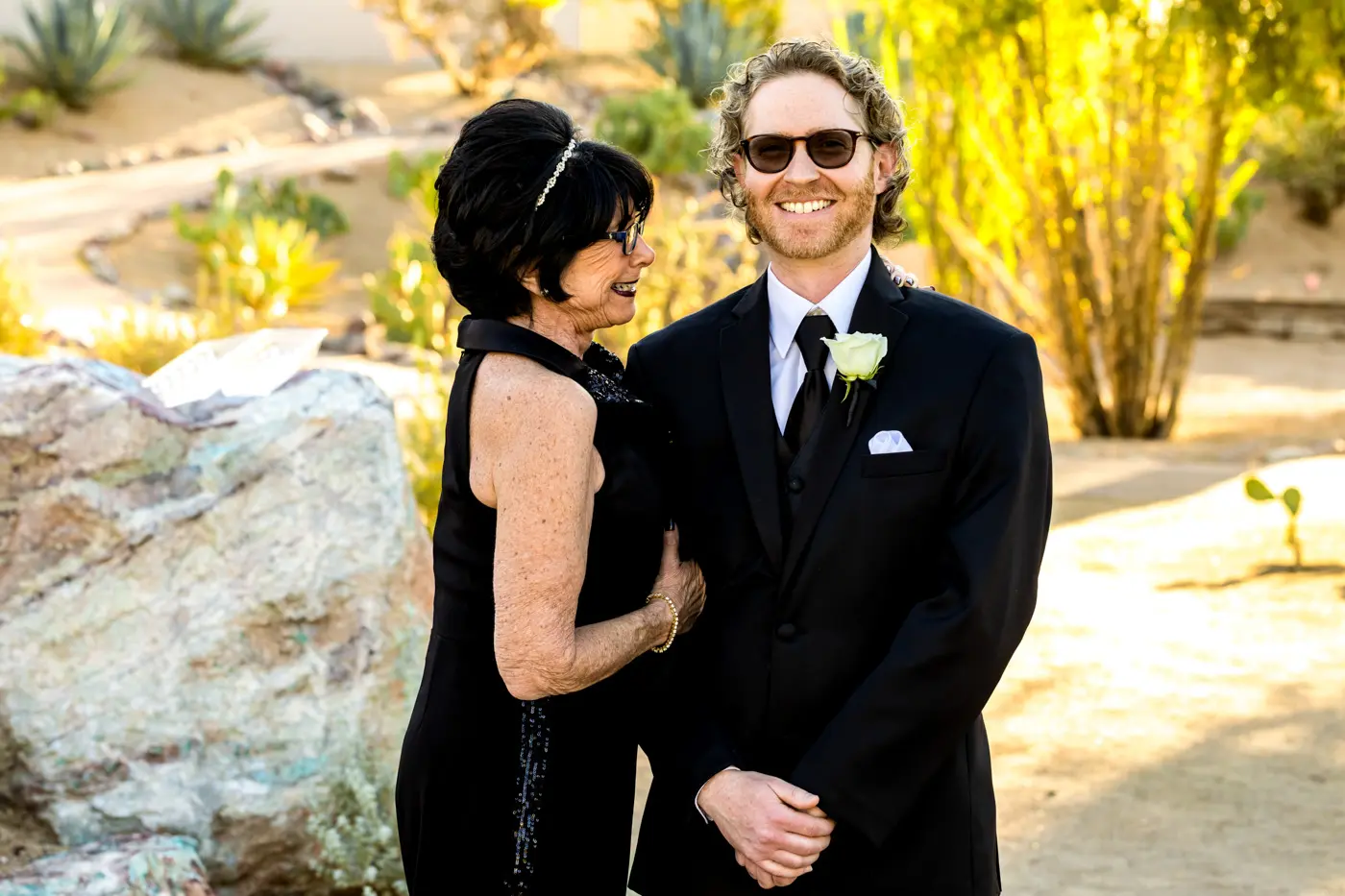 Matriarch and groom smiling outside