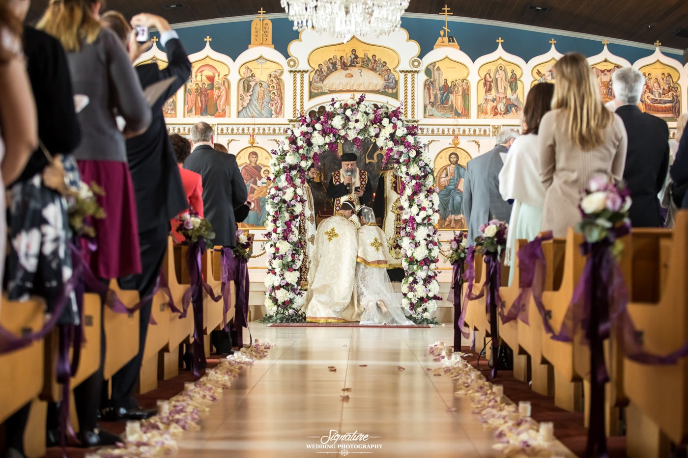 Bride and groom knelt at church alter during ceremony