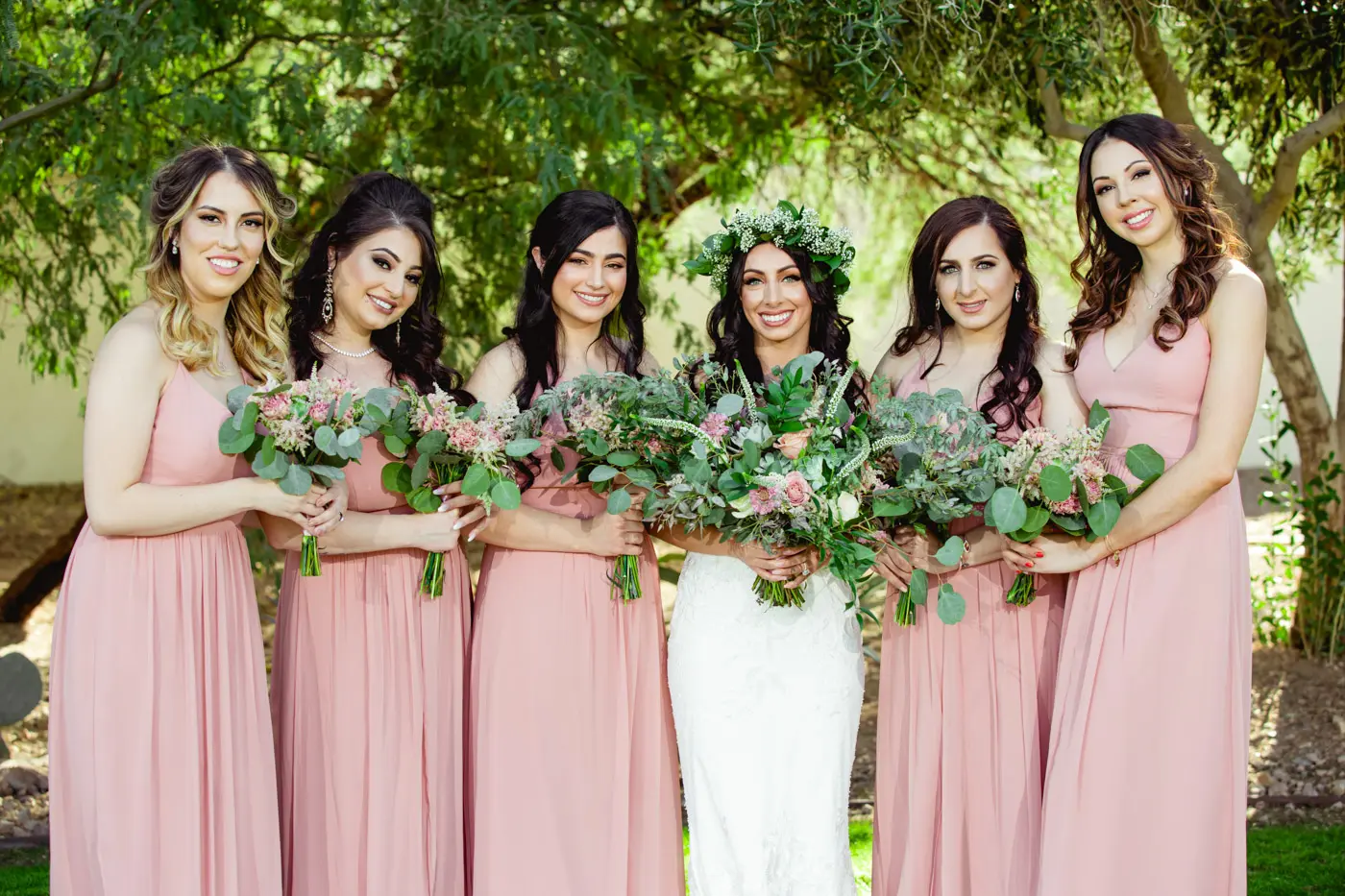 Bride and bridesmaids smiling at camera