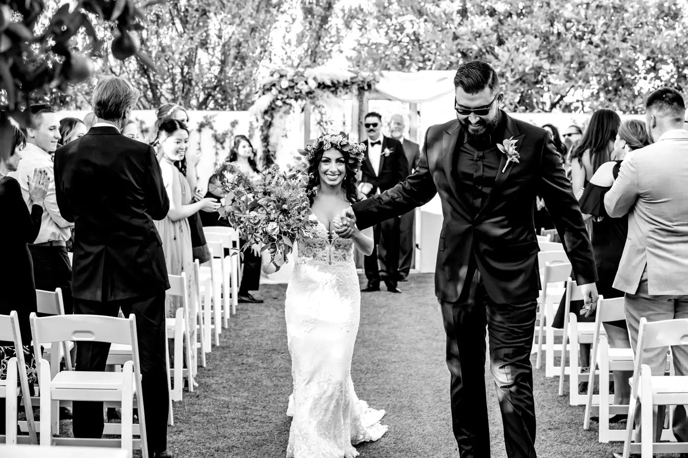 Bride and groom walking down isle black and white