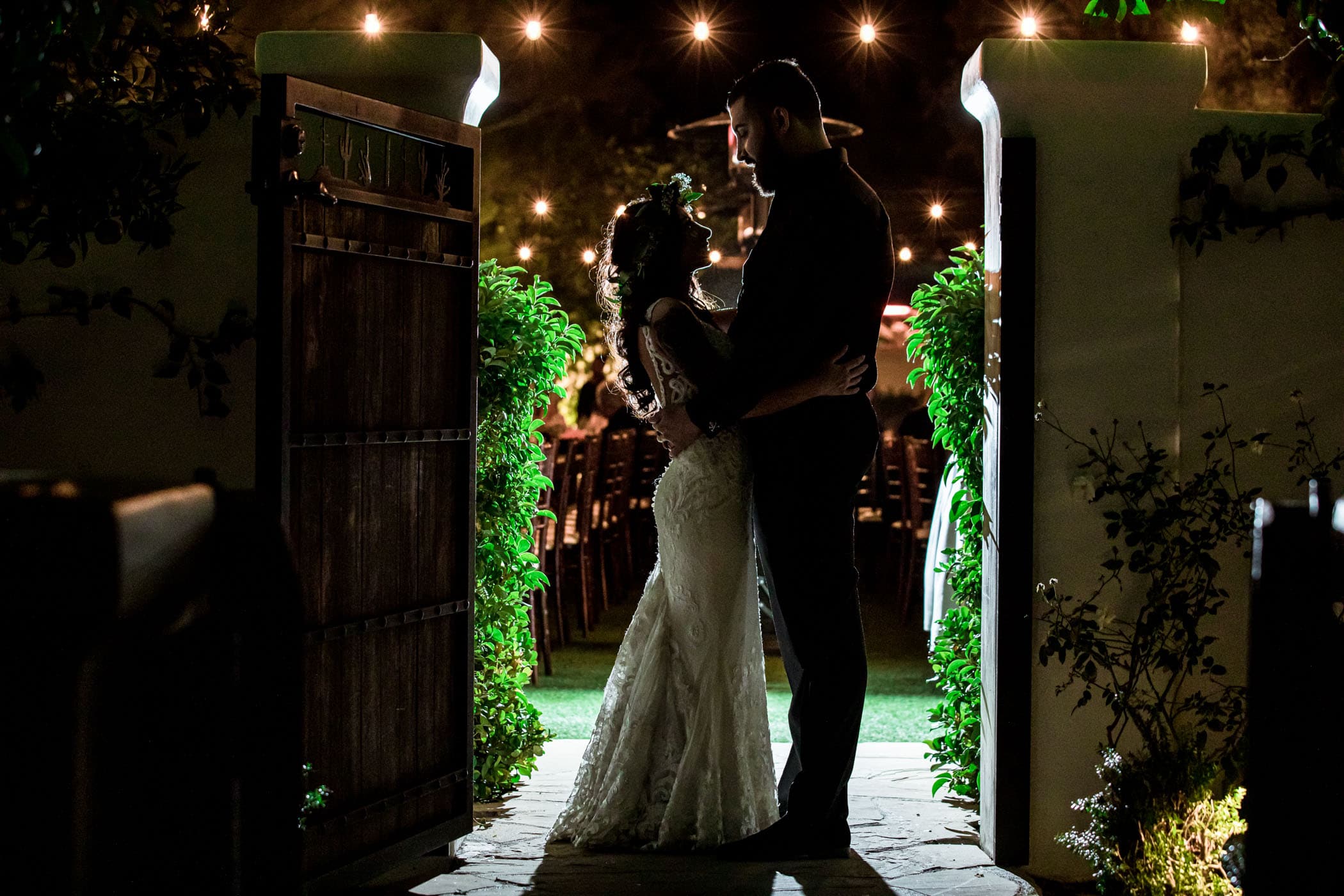 Bride and groom hugging in doorway silhouette