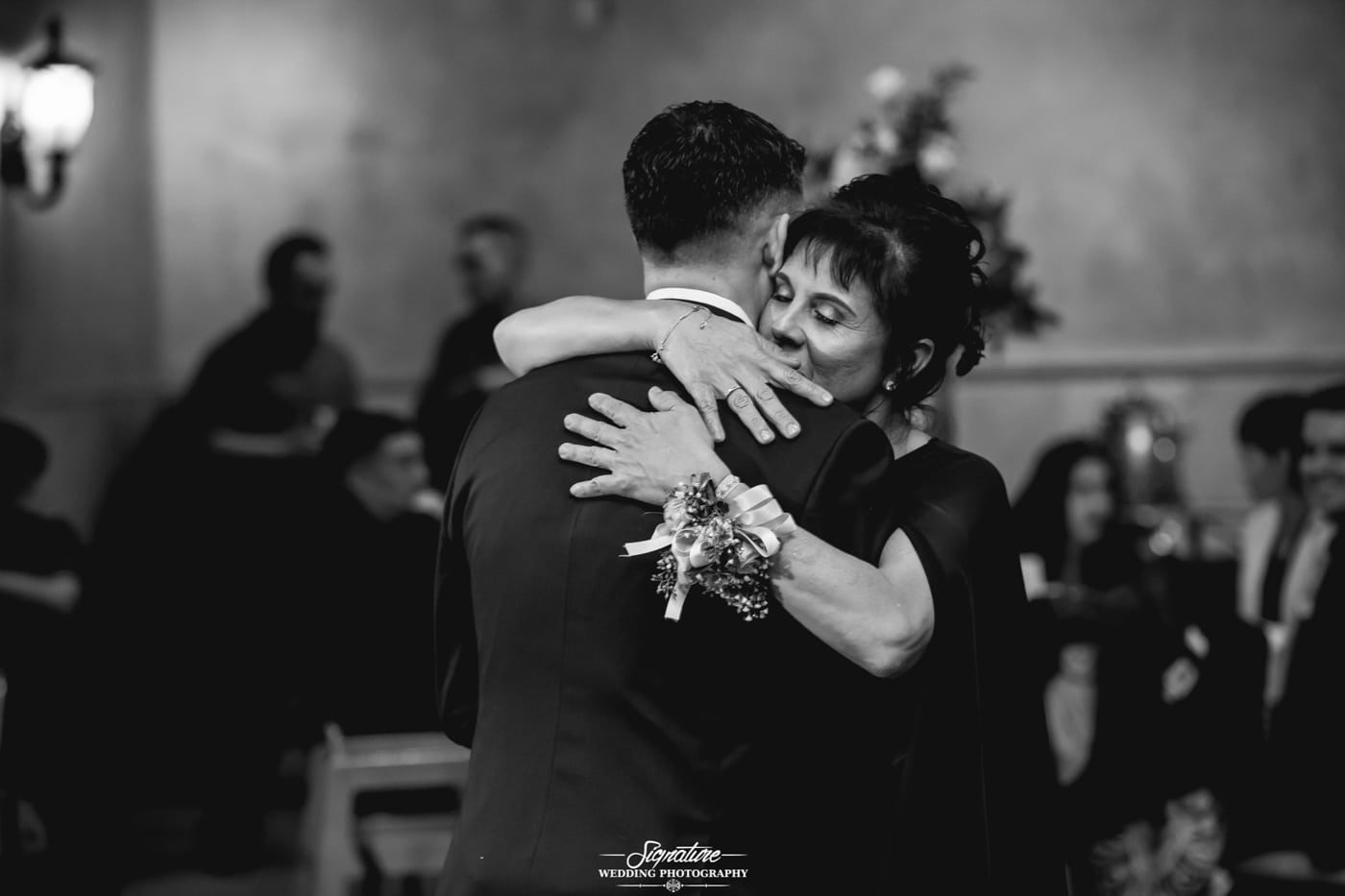 Mother hugging groom dancing together black and white