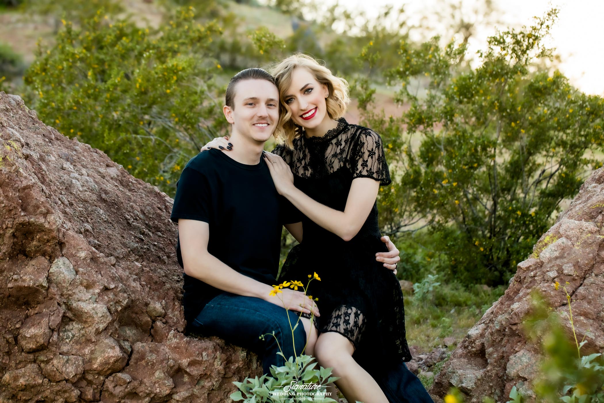 Couple sitting together on rock in desert