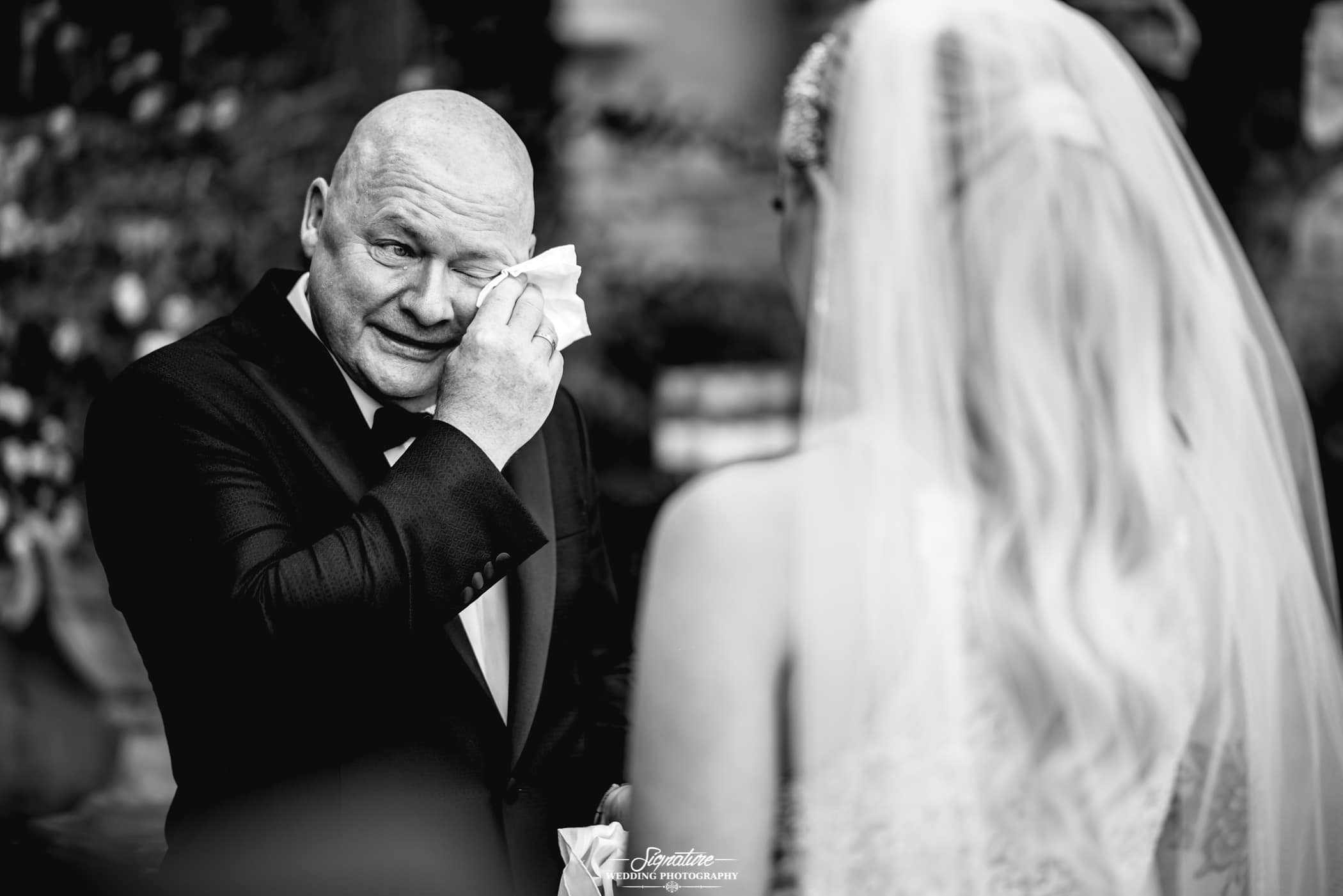 Father wiping tears seeing bride first look