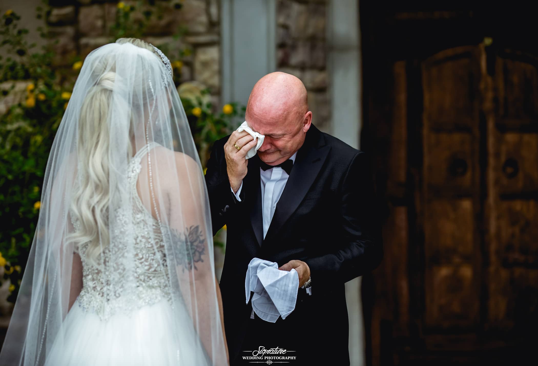 Father wiping tears seeing bride first look