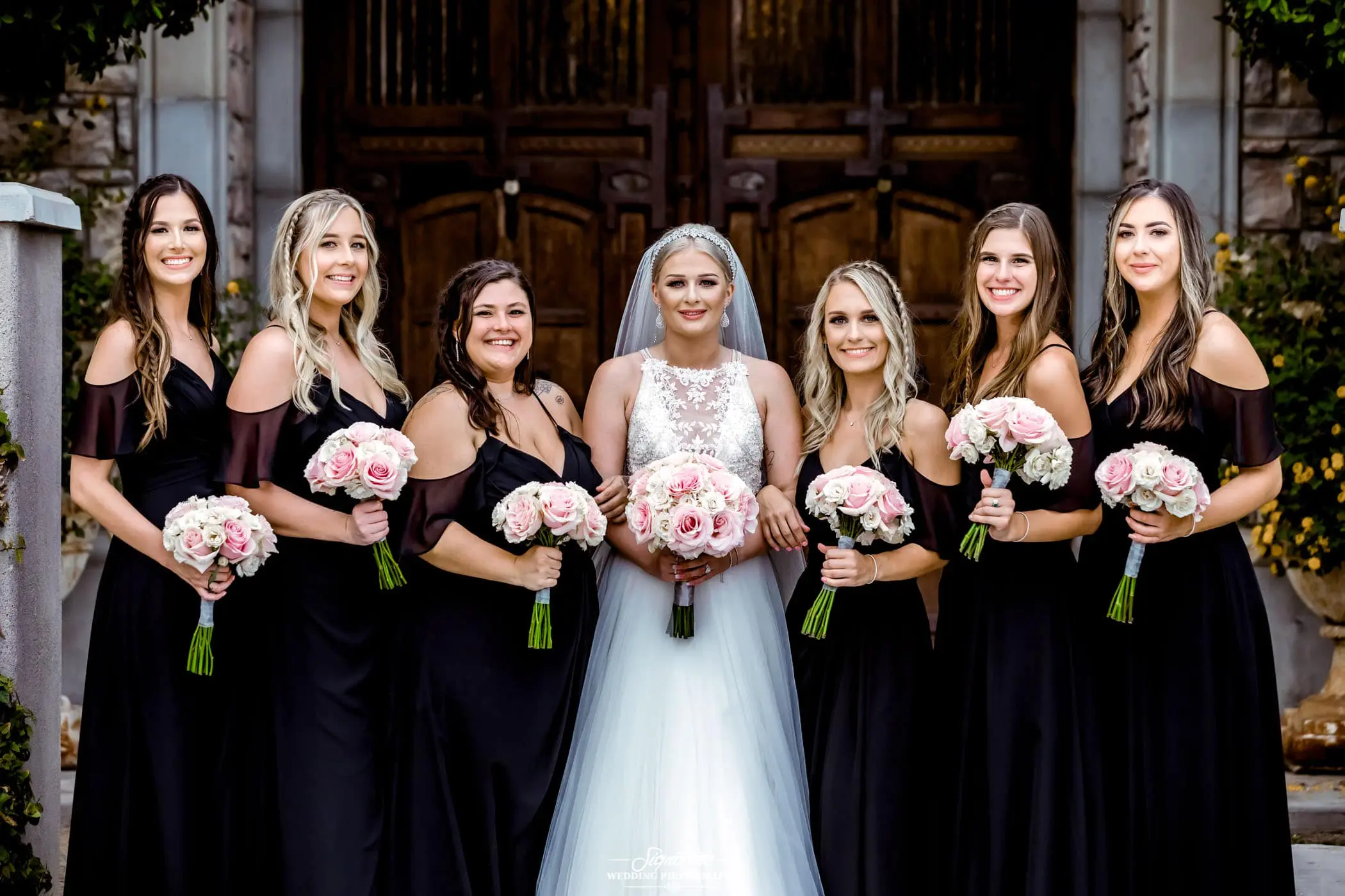 Bride and bridesmaids smiling at camera
