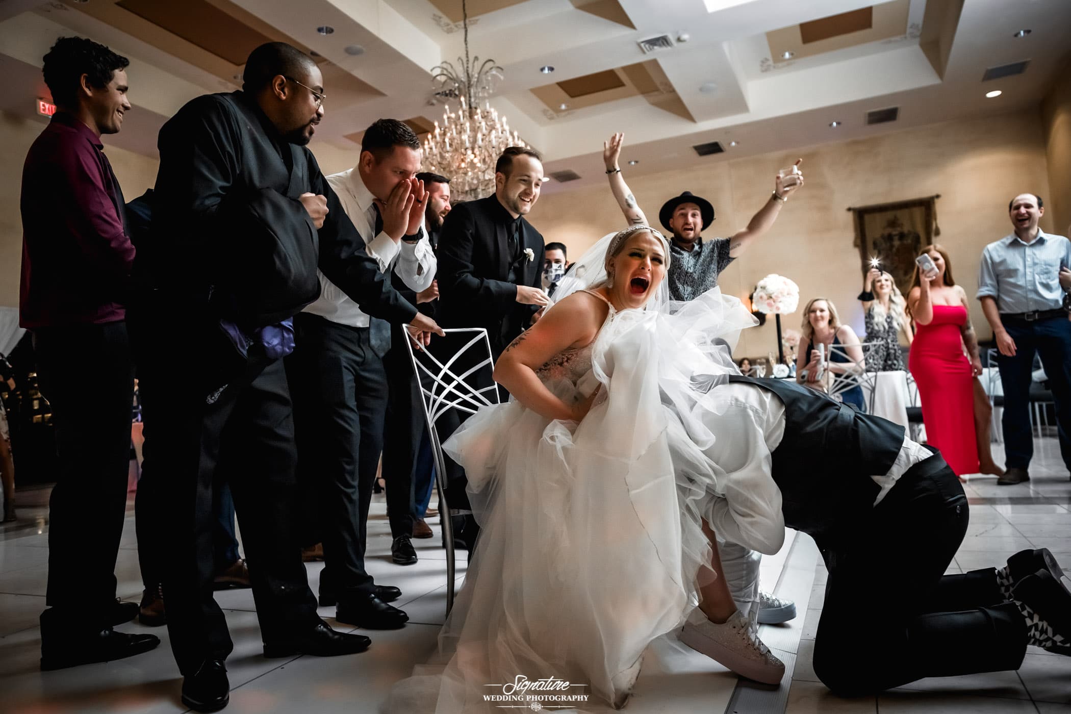 Person under brides dress for garter toss