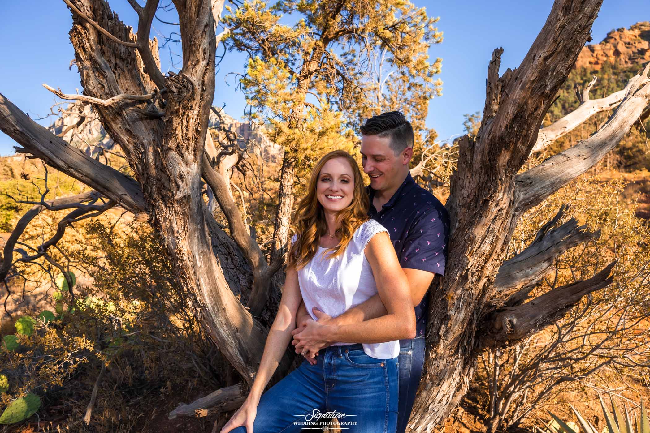 Man embracing woman in front of desert tree