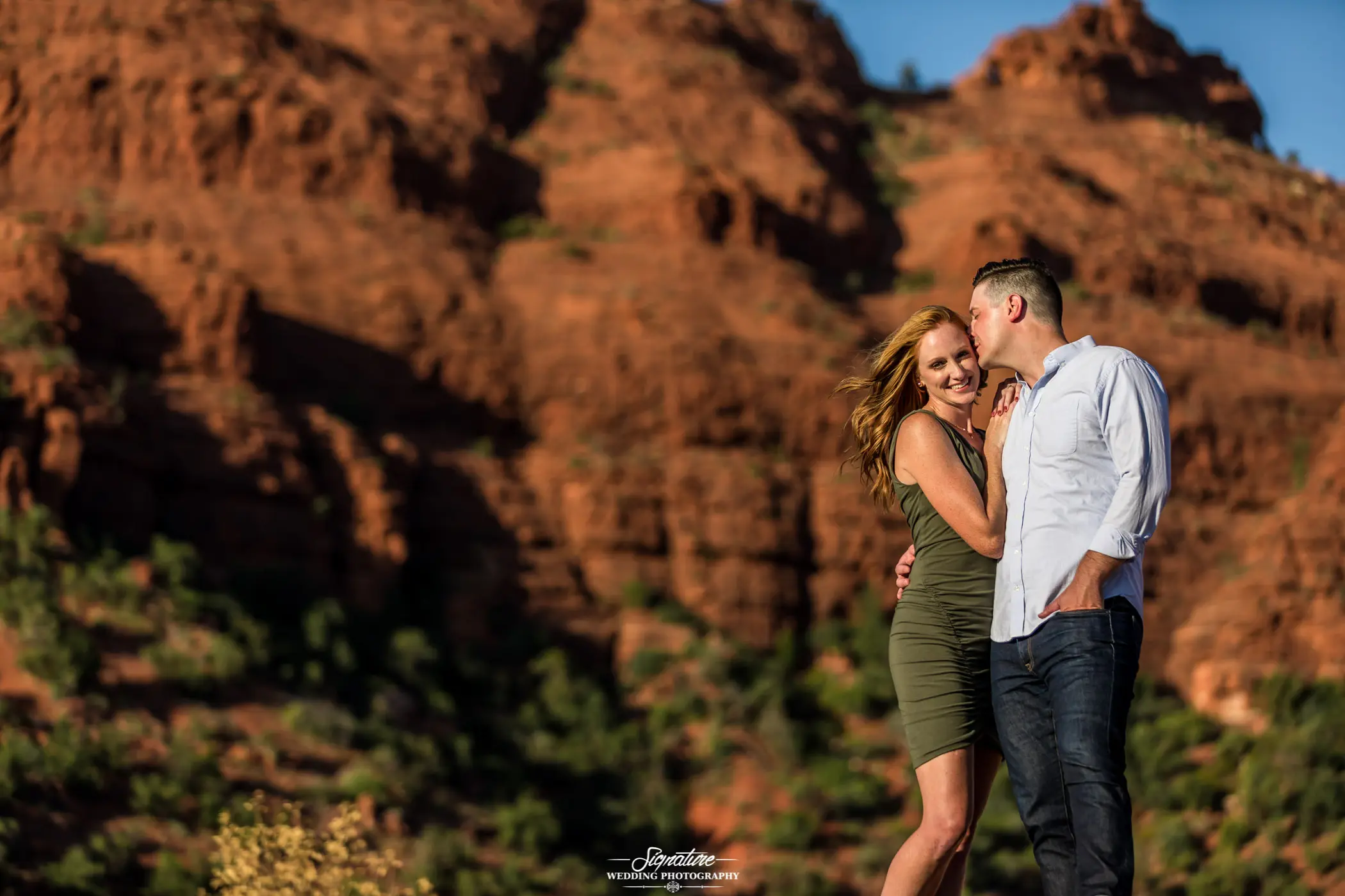 Man kissing woman on cheek in desert