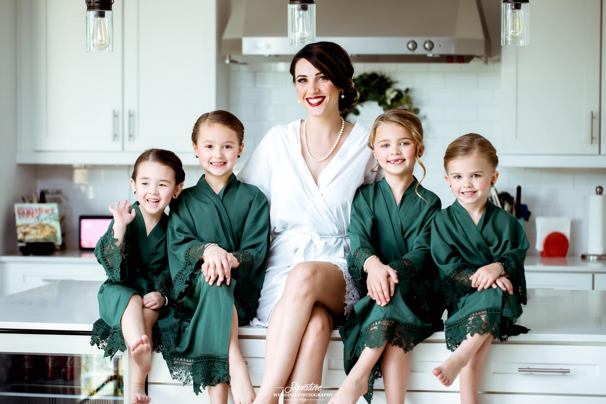 Bride and flower girls in robes sitting with legs crossed